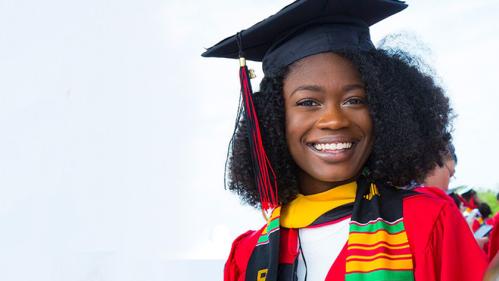 African American student wearing cap and gown and smiling during her graduation
