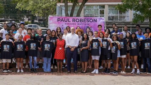 President Holloway, Chancellor-Provost Francine Conway, Senior Vice President for Equity, Enobong (Anna) Branch posing in front of a large students at the Paul Robeson Success Institute closing event