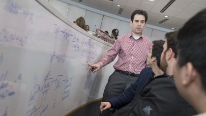 Assistant Professor of Chemical and Biochemical Engineering Fuat Celik assisting his students in the Richard Weeks Hall of Engineering Table Learning Lecture Hall.