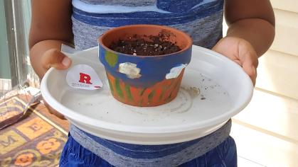 Close up of child's hands holding a painted pot