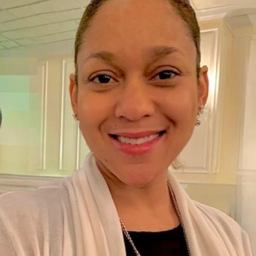 Smiling woman wearing a white sweater.