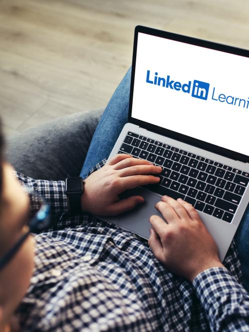 man-using-laptop-wearing-glasses-cushioned-furniture-blurred-background-high-quality-photo-linkedin-learning