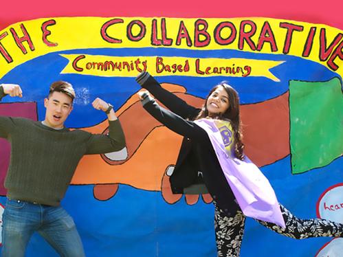 Young asian american male student and young female indian american student standing smiling and having fun in front of a painted wall that says "The Collaborative - community based learning")