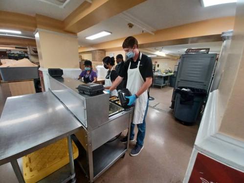 Eddie Malague, a soon-to-be-senior at Rutgers, helping prepare to-go meals at Elijah's Promise.