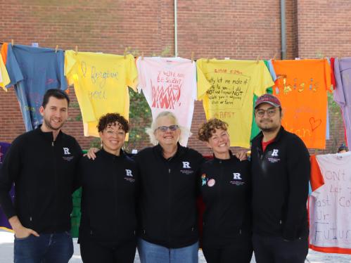 VPVA staff members pose for a photo in front of the Clothesline Project. From L-R: Will Zarillo, Rebecca Vazquez, Lisa Smith, Erin Snyder, Jonel Vilches. 